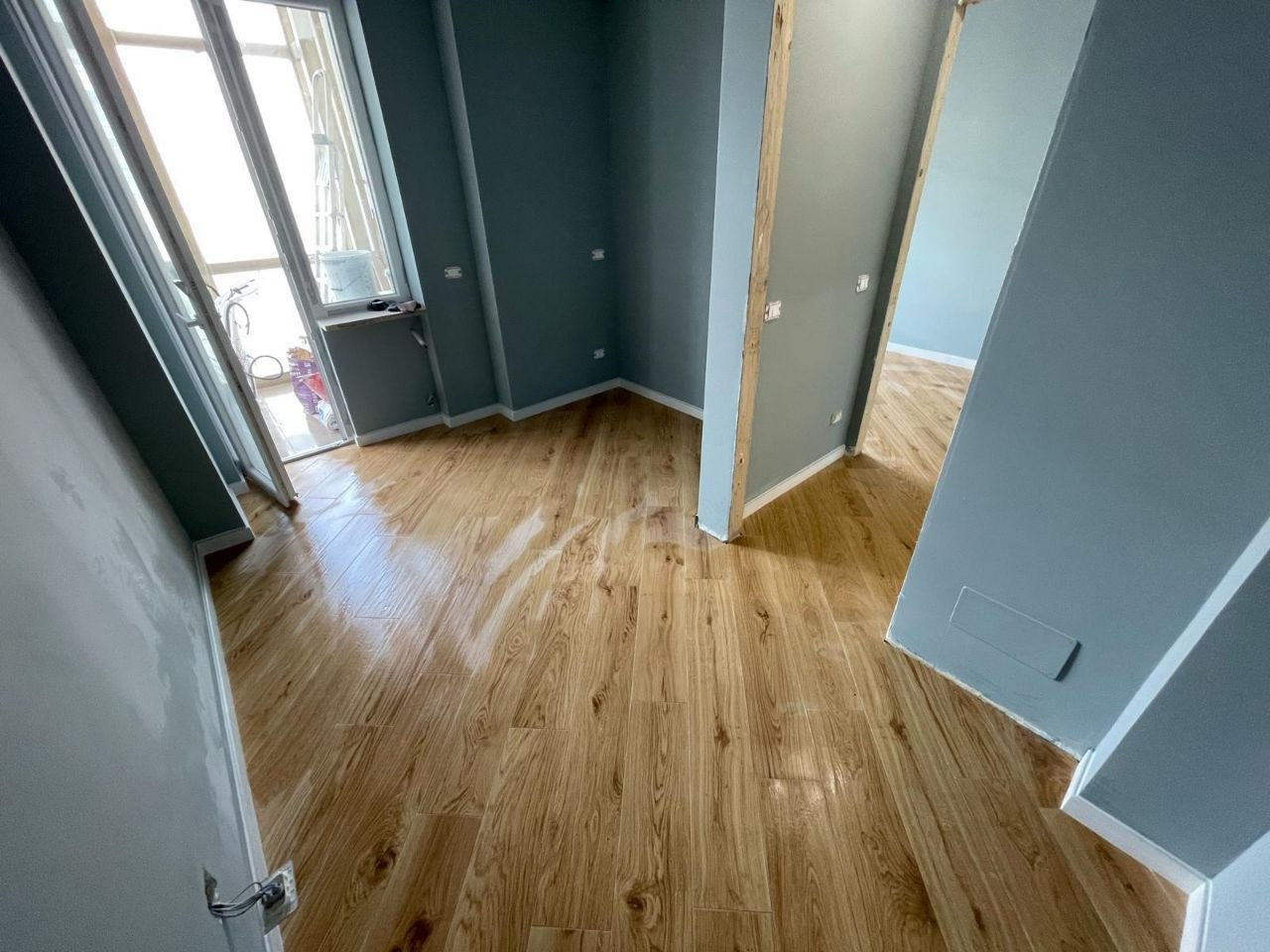 Passaggio interno con pavimento effetto legno e pareti rifinite